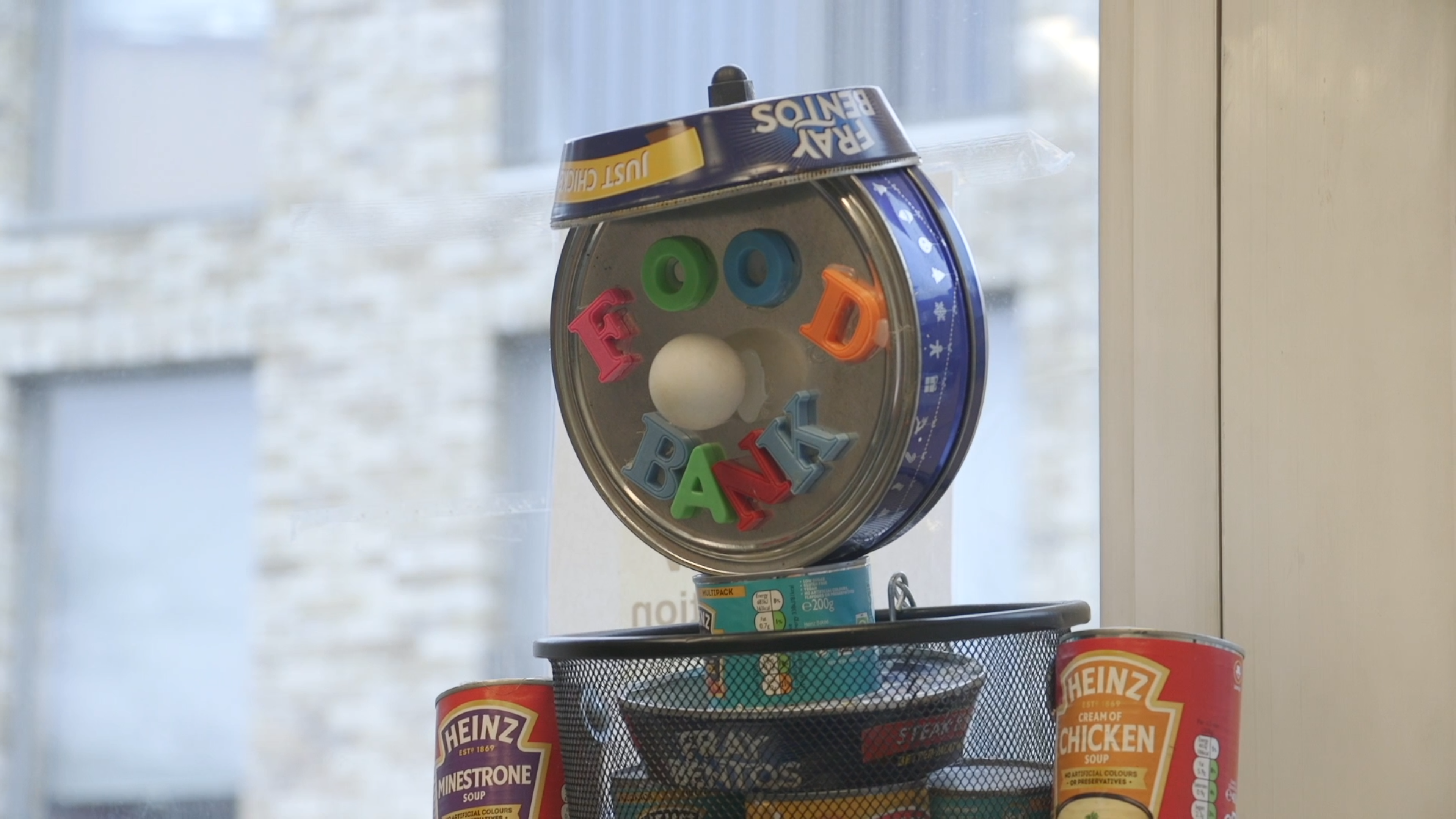 Food tins and painted letters spelling FOOD BANK at Bow Food Bank